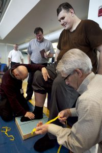 Igor Vovkovinskiy, of Minneapolis, currently the tallest man in the United States at seven feet eight inches, has an imprint taken of his foot by technicians as part of a shoe fitting at Reebok headquarters, in Canton, Mass., Thursday, May 3, 2012. Vovkovinskiy, who has a shoe size between 22 and 26, says he's had 16 surgeries in six years to fix problems created by shoes that didn't fit. Reebok is providing the shoes at no charge. (AP Photo/Steven Senne)